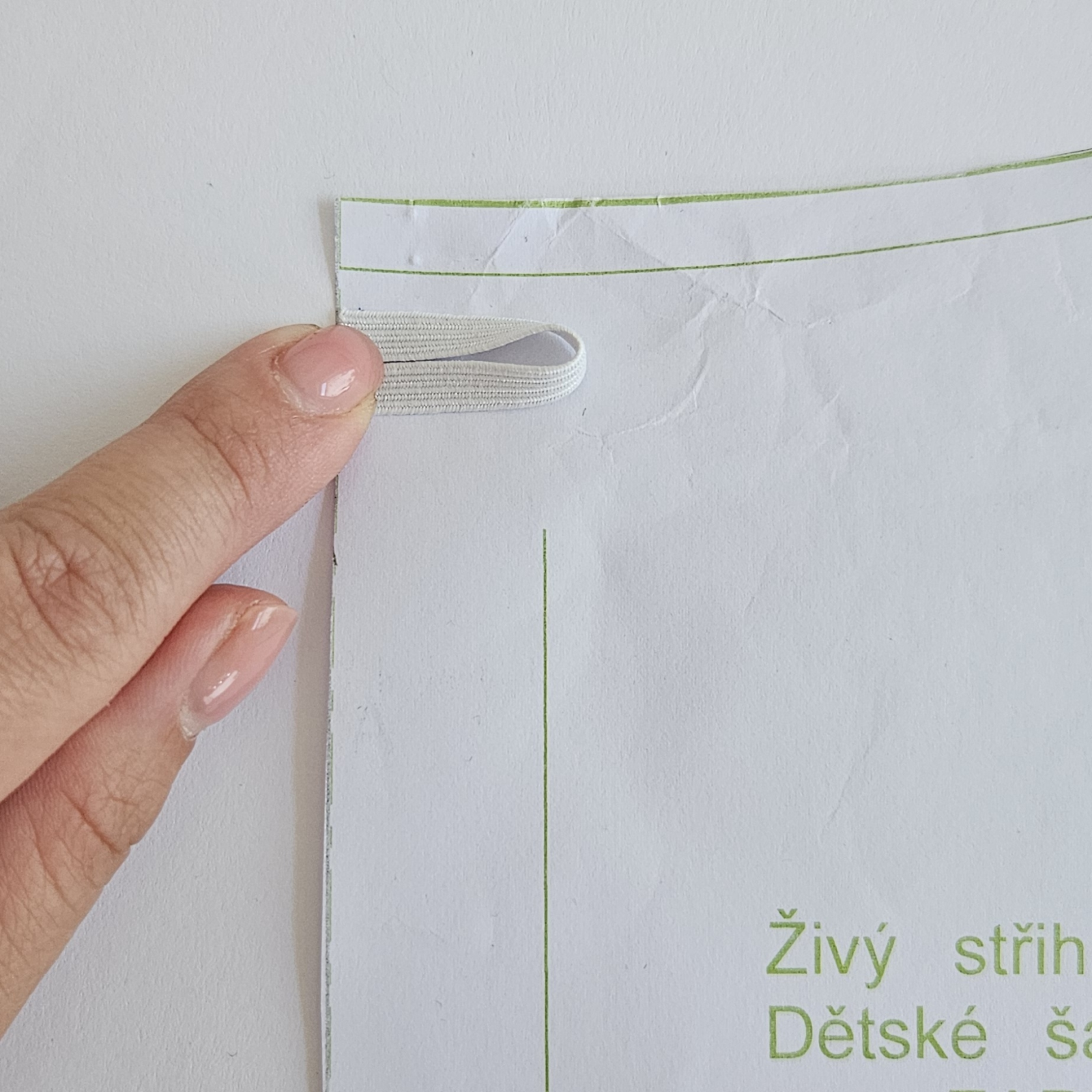 Na střihu si zakreslím umístění gumičky, je asi 1,5 cm od okraje